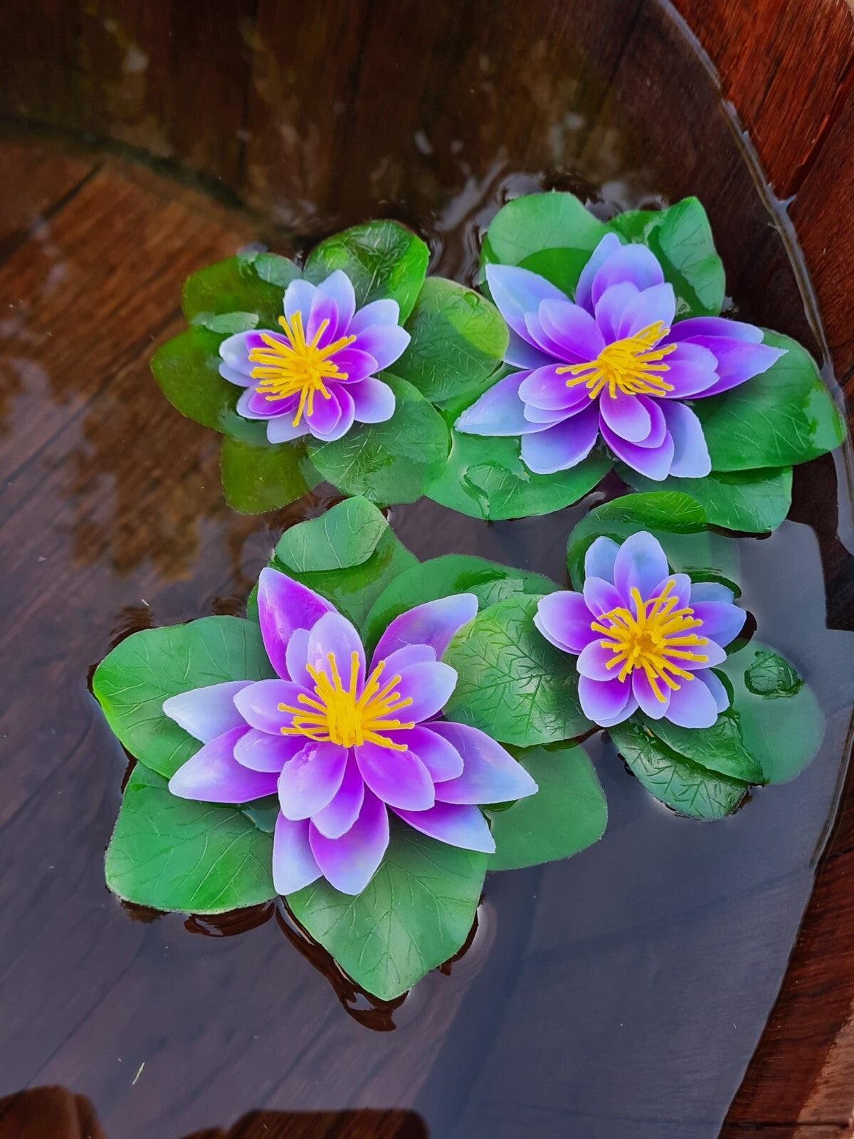 Zwei künstliche Seerosen in Lila und Weiß, je 15x10cm, als Gartenteich-Deko, auf einem Wasserpflanzen-Design.